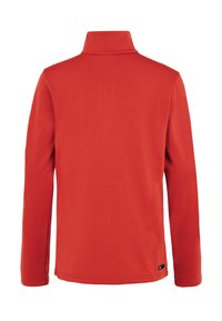 Czerwona kurtka z długim rękawem, wysokim kołnierzem, gładkimi plecami i małą czarną metką marki blisko dolnego brzegu po prawej stronie.