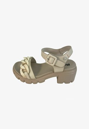 Sandalia beige con suela gruesa, con una correa trenzada y un hebilla ajustable en el tobillo. Fabricada con materiales sintéticos, de textura suave.