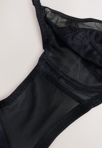 Black mesh and lace bra cup with floral embroidery, featuring adjustable strap and sheer fabric details on a neutral background.