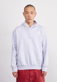Felpa leggera color lavanda con tasca a marsupio, cappuccio con coulisse e dettaglio logo bianco sul petto. Tessuto morbido con polsini e orli a coste.