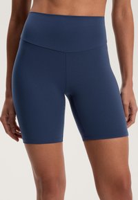 Sötétkék kerékpáros rövidnadrág, rugalmas anyagból készült, magas derékkal és testhezálló kivitelezéssel, alkalmas aktív viseletre vagy hétköznapi használatra.