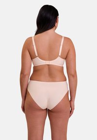 Ensemble soutien-gorge et bikini en tissu pêche clair. Conception sans couture avec des bretelles réglables et une fermeture à crochets au dos. Texture lisse.