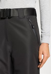 Sorte tekniske bukser med en glat, mat tekstur, en bred linning med en robust spænde og en lynlåslomme i siden til opbevaring.