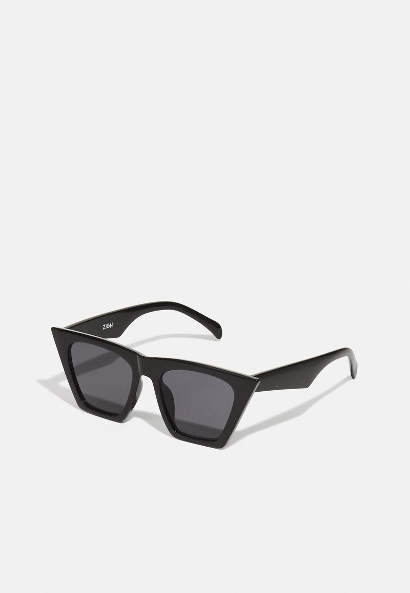 Ochelari de soare negri cu un design geometric, unghiular. Lentile întunecate, cadru din plastic gros și branding subtil pe brațul interior.