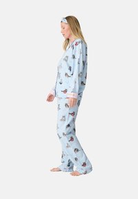Blaues Pyjama-Set mit Katzenmuster, langärmliges Oberteil mit gestreiften Bündchen und passenden Hosen. Weicher Stoff, lockere Passform und leichte Textur.