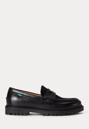Mocassin en cuir noir avec semelle épaisse, bout arrondi et étiquette verte Polo sur le côté.