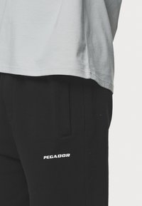 Pegador LOGO JOGGER - Træningsbukser - washed black/white gum