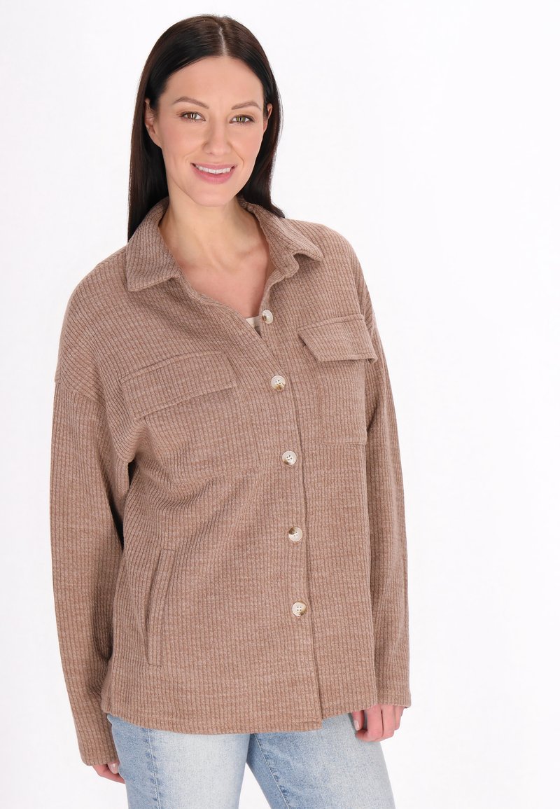 Camicia button-up marrone a coste con colletto, due tasche frontali e una vestibilità rilassata. Tessuto morbido e leggera traspirabilità.
