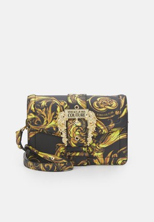 Czarna i złota torebka na ramię Versace Jeans Couture z ozdobnym kwiatowym wzorem i dekoracyjną złotą klamrą na przedniej klapie.