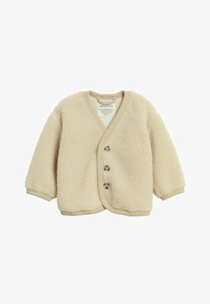 Beżowy sweter z polaru z dekoltem w serek, długimi rękawami i zapięciem na cztery okrągłe guziki. Teksturowana, miękka tkanina, ściągacz przy wykończeniach.