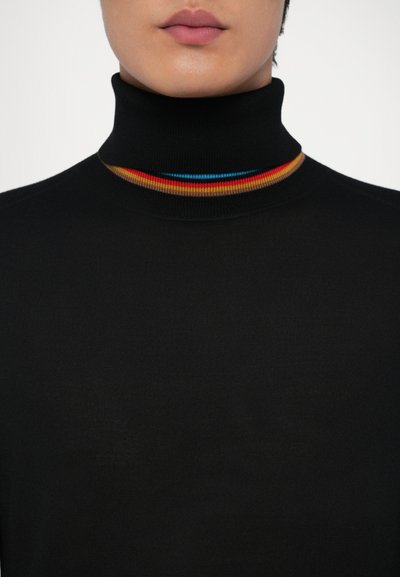 Crna turtleneck majica sa uskim dizajnom, s višebojnim prugastim izrezom u crvenoj, narančastoj i plavoj boji. Mekana tekstura.