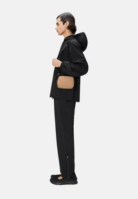 Giacca nera impermeabile con cappuccio, pantaloni neri abbinati e scarpe nere. Borsa a tracolla marrone chiaro. Design minimalista, forma elegante.