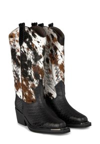Botas de vaquero con pie y tacón negros texturizados, caña alta cubierta con un patrón de piel manchada en marrón, negro y blanco, con costuras decorativas.