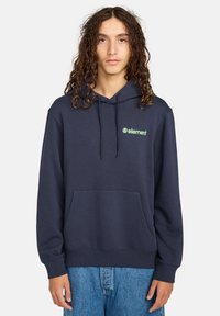 Felpa con cappuccio blu navy in misto cotone, dotata di tasca frontale, polsini a costine e un logo verde sul lato sinistro del petto.
