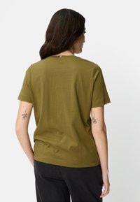 Olive green short-sleeve t-shirt made of soft fabric, featuring a round neckline and a straight cut with a small seam detail at the back.