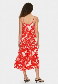 Maksivakums ar spageti siksnām, ar sarkanu ziedu rakstu uz krēmkrāsas fona, ar slāņainu dizainu un iz plecu galu.