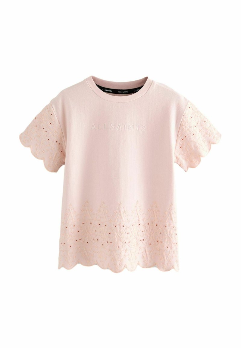 Camiseta de algodón rosa claro con mangas bordadas con borde festoneado y patrones decorativos, con un logo de la marca sutil en el frente.