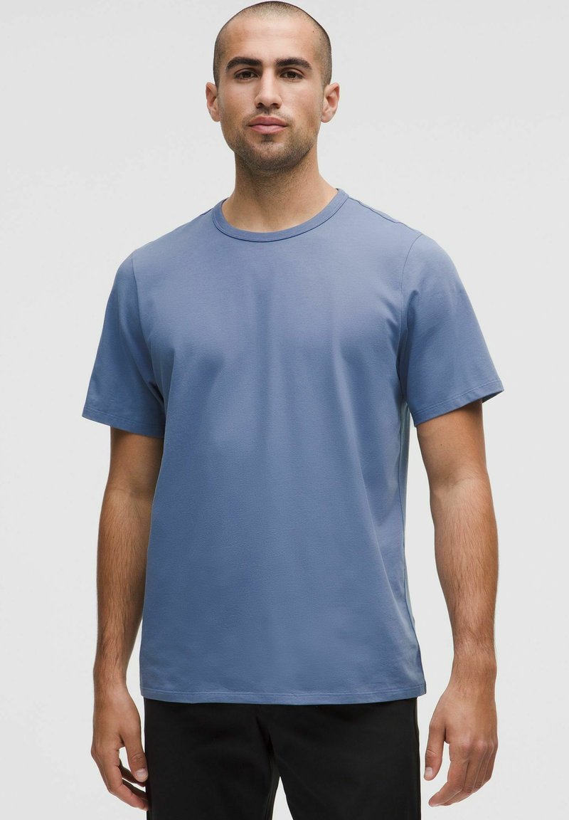 Tricou cu mânecă scurtă, guler rotund, dintr-o țesătură ușoară de bumbac în nuanța albastru deschis. Textură netedă, cu o croială lejeră, fără modele sau accente vizibile.