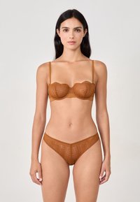 Conjunto de lencería marrón con encaje que incluye un sujetador balconette con bordes ondulados y braguitas de cintura alta a juego, ambas con patrones intrincados.