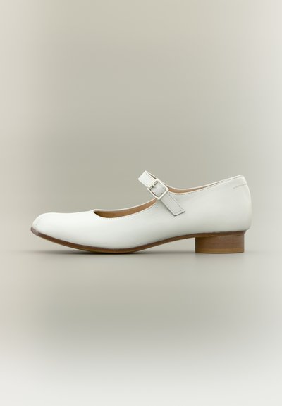 Chaussure Mary Jane en cuir blanc avec un petit talon en bois et une bride à boucle argentée, vue de côté extérieur sur un fond neutre.