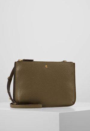 Olivengrøn tekstureret læderhåndledsrem med guldlynlås og lille guldlogo foran, vist på hvid piedestal mod grå baggrund.