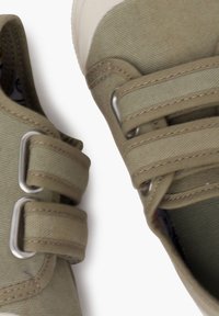 Scarpe verdi in tela con doppie cinghie in Velcro, tessuto testurizzato e punta in gomma, con dettagli di cucitura a contrasto.