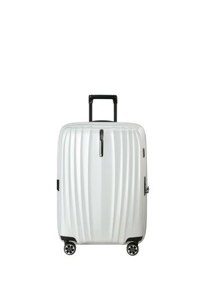 Weißer Hartschalenkoffer mit schwarzem ausziehbarem Griff und vier Drehrollen, aufrecht stehend vor weißem Hintergrund.