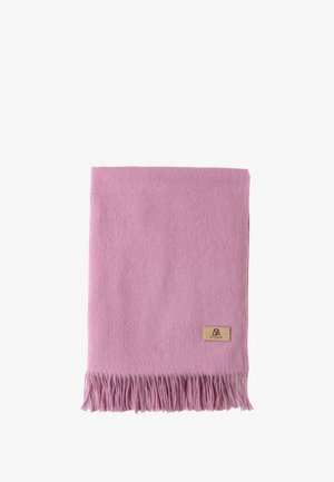 Sciarpa di cashmere rosa con orli frangiati, indossata sopra un maglione chiaro e una gonna scura. Un cerchietto grigio completa il look, aggiungendo texture.