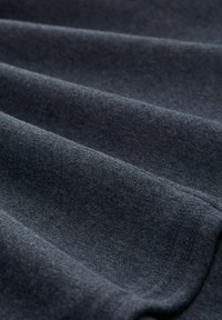 Tessuto blu scuro con una superficie liscia, caratterizzato da pieghe e bordi morbidi. Il materiale appare leggero e a maglia fine.