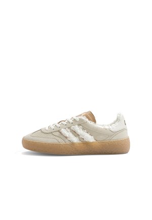 Baskets en daim beige avec des rayures blanches duveteuses et une doublure, des lacets blancs et une semelle en caoutchouc marron clair texturée.