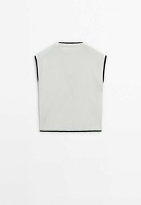 Veste blanche sans manches en maille avec bordure noire autour des emmanchures, de l'encolure et de l'ourlet, vue de dos sur un fond blanc uni.