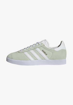 Baskets Adidas Gazelle en daim vert clair avec des bandes blanches, une semelle blanche, des lacets blancs et une languette blanche au talon, vues de côté.