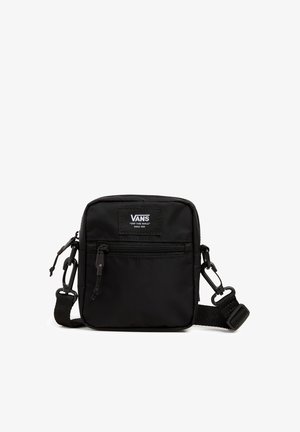 Sac bandoulière compact noir Vans avec poche avant zippée, sangle ajustable et patch logo "Off The Wall" sur fond blanc.