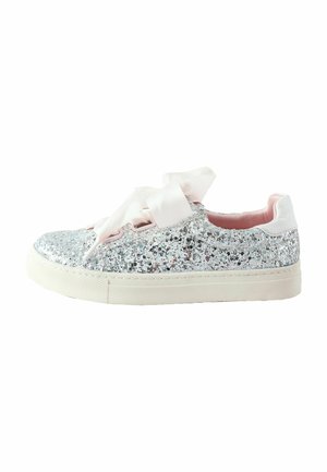 Niedriger Sneaker, bedeckt mit silbernem Glitzer, mit breiten rosa Satinschnürsenkeln und einer weißen Gummisohle vor weißem Hintergrund.