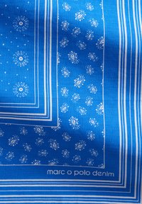 Niebieska tkanina w wzory z białymi motywami paisley i paskami; zawiera markę "marc o polo denim". Miękka tekstura, kształt prostokątny.