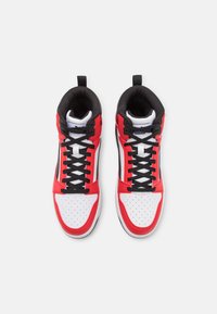 Korkeadeilised spordijalatsid punases, valges ja mustas. Omab perforeritud varbapoolt, musti paelu ja pehmendatud kaelust. PUMA logo igal keelel.