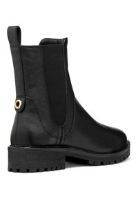 Bota negra de cuero hasta el tobillo con paneles laterales elásticos, puntera redonda y suela de goma texturizada. Presenta un acento metálico en el tacón.