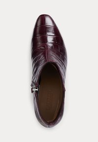 Bottines en cuir bourgogne avec une texture crocodile, bout pointu, fermeture éclair sur le côté et doublure intérieure lisse.