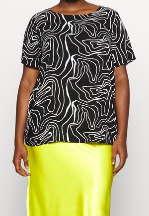 Black short-sleeve top with white abstract line pattern; relaxed fit. Paired with a smooth, bright yellow satin skirt.