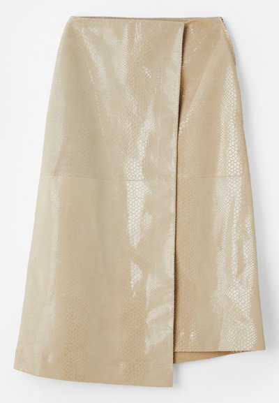 Jupe en simili cuir beige avec un motif serpent texturé et brillant ; dotée d'un design enroulé et d'une fente sur le côté pour plus de détails.