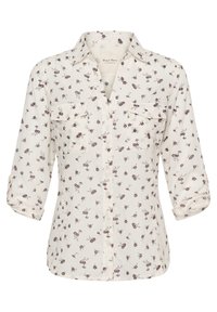 Chemise boutonnée crème clair avec un motif floral bordeaux et vert. Comprend deux poches avant et des manches retroussées. Texture de tissu lisse.