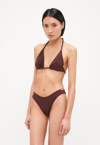 Bikini marron côtelé avec un haut triangulaire et un bas taille basse, doté de fines lanières et d'un petit accent doré sur le côté. Design à texture douce.