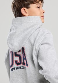 Grey hooded sweatshirt made of cotton blend, featuring a large "USA" graphic in red and navy on the back with "NEW YORK CITY" underneath.