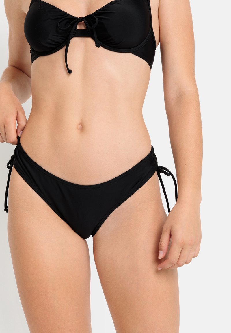 Črn bikinij komplet, ki vključuje oblikovane skodelice s kravato spredaj in nastavljive hlačke z bočnimi zavezanimi trakovi, ki ponujajo eleganten material in klasičen dizajn.