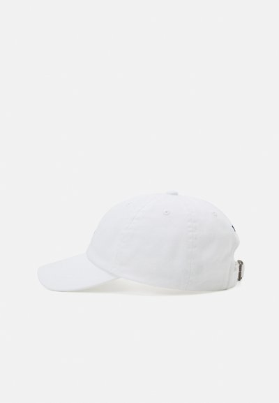 Witte pet met een gebogen rand, gemaakt van katoen. Bevat zes ventilatieoogjes en een verstelbare metalen sluiting aan de achterkant. Minimalistisch ontwerp.