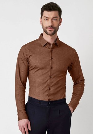 Bruine lange mouwen shirt in gestructureerde stof met een button-down kraag, voorzien van knopen aan de voorkant en een slim fit ontwerp. Gecombineerd met donkere broeken.