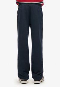 Marineblå sweatpants med en afslappet pasform, elastisk talje, sidelommer og en glat tekstur. Simpelt design uden yderligere mønstre.