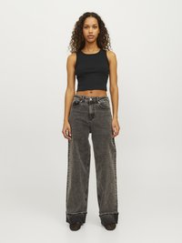 Svart rippad crop top matchad med högmidjade, löst sittande grå denimjeans med en urblekt tvätt och uppvikta fållar.