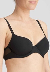 Sostén negro con aros y copas de espuma, tirantes finos ajustables y paneles laterales de malla. Textura suave y un diseño curvado y soporte.