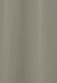 Tela verde claro con una superficie texturizada, que presenta sutiles variaciones de tono y una apariencia suave y tejida. Sin patrones o acentos distintivos.